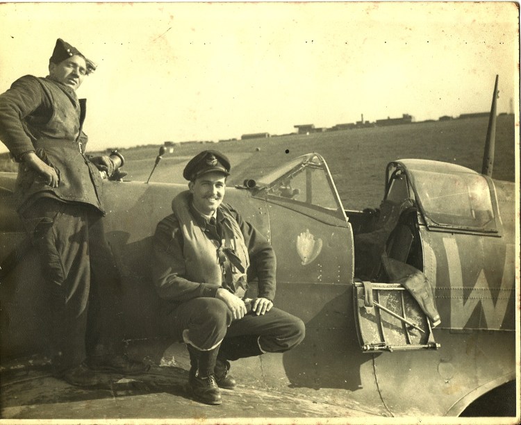 Warren M. Lightbourn kneeling by his airplane